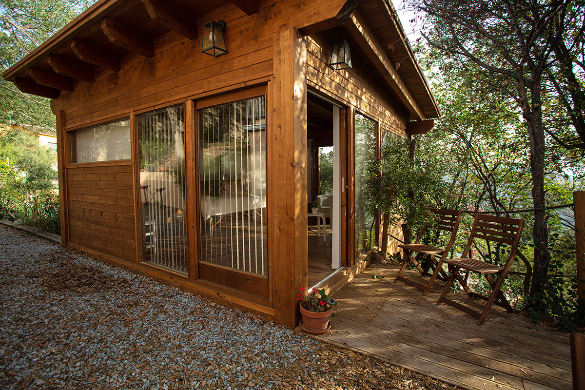 l'exterior de la casa de fusta a collserola, envoltada del bosc.